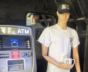 Photo of our ATM machine and a mannequin wearing our cap and tee shirt. It's holding a Vivian's mug.